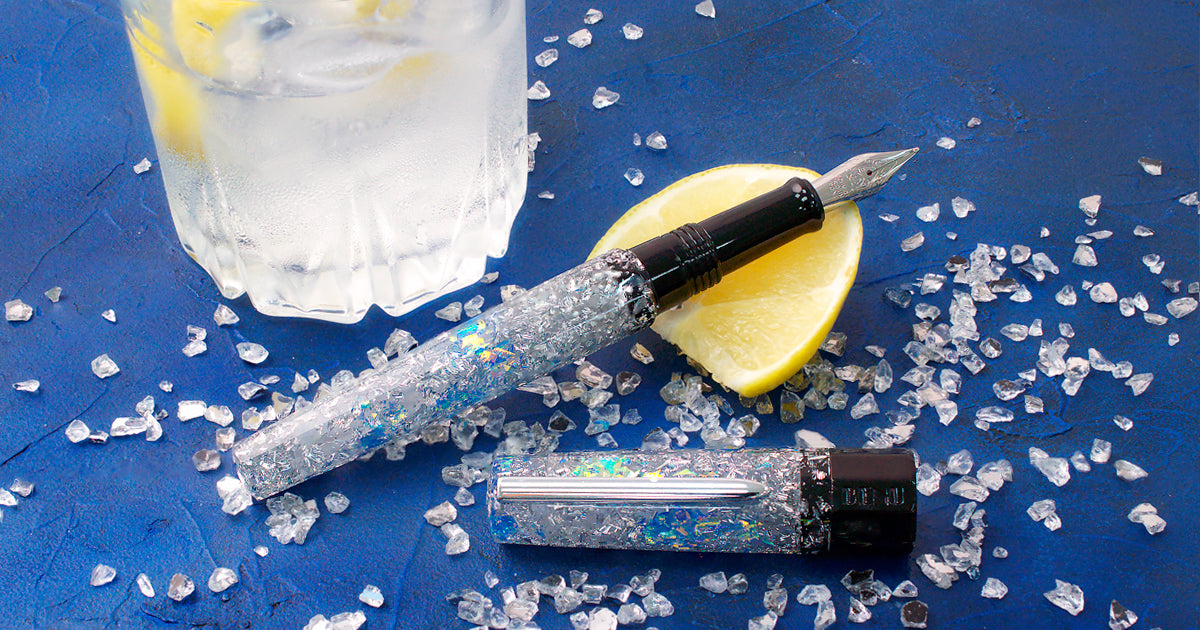 Sparkling benu euphoria vodka on the rocks fountain pen next to a glass on a lemon