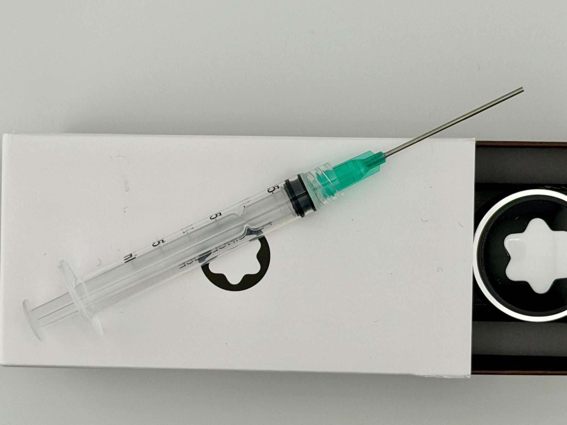 Blunt-tipped syringe on a bottle of montblanc fountain pen ink