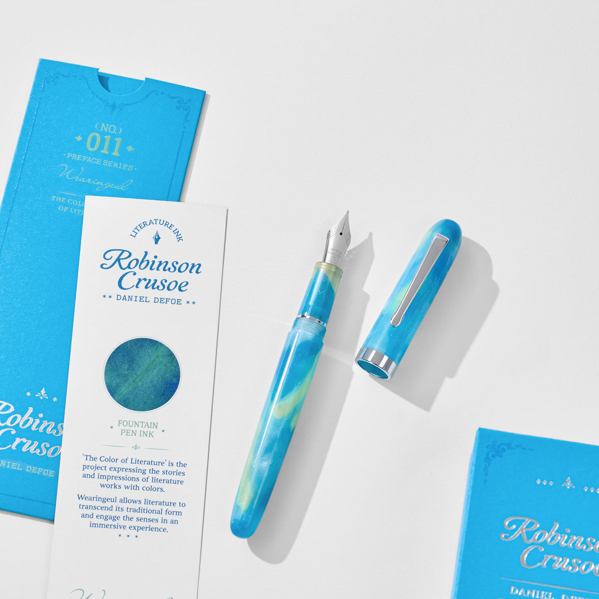 Wearingeul Robinson Crusoe fountain pen uncapped beside literature and ink cards