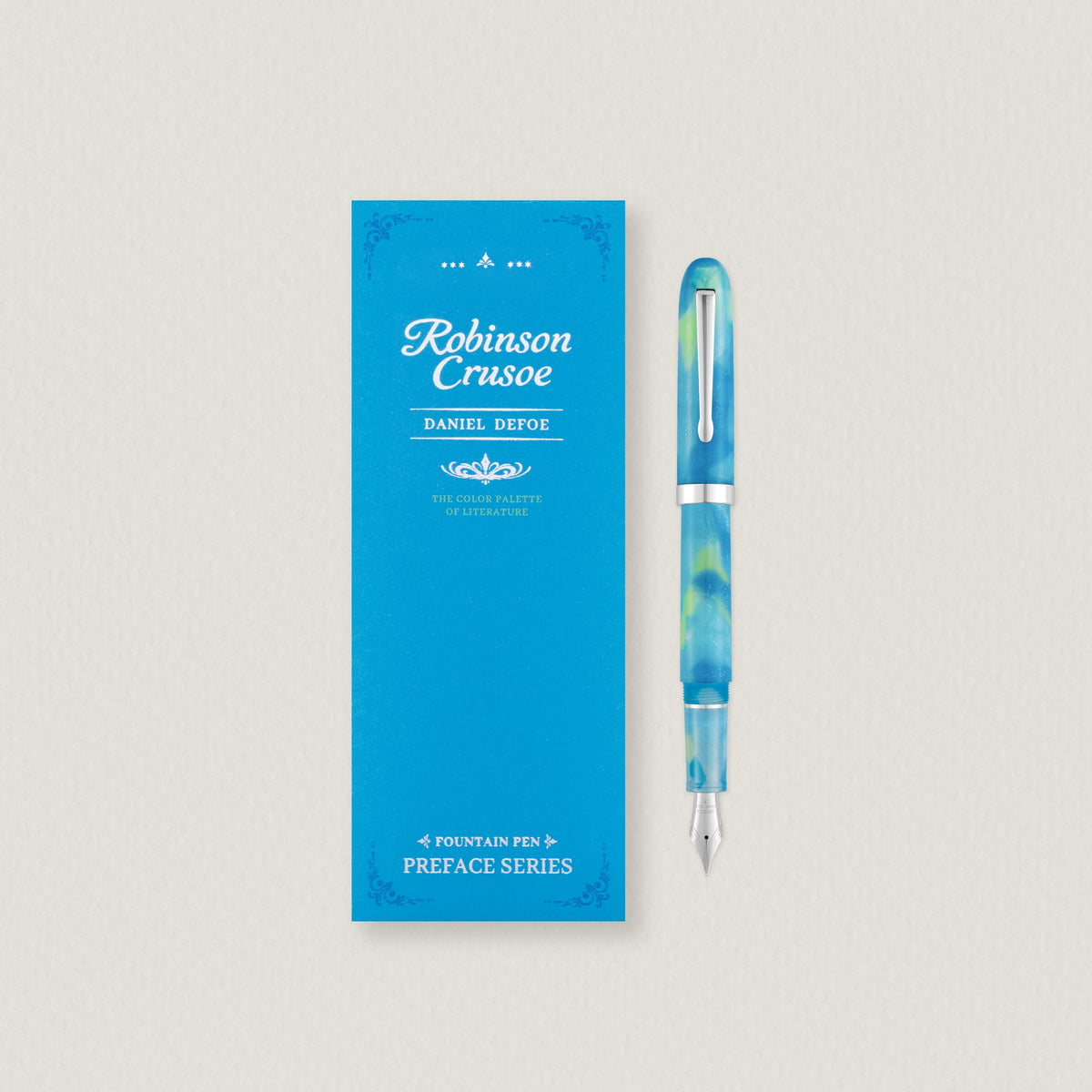 Wearingeul Robinson Crusoe fountain pen in turquoise and green beside its blue book-style box